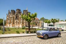 Portugal - Classic Car Road Trip Portugal: De classic Mini in de stad Batalha voor het klooster van Batalha. Bij de stad Batalha vond in 1385...