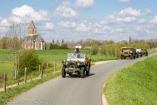 Herdenking Operation Quick Anger 2019 - Herdenking Operation Quick Anger 2019: Enkele militaire voertuigen uit WOII rijden op de dijk bij het dorp Oud-Zevenaar, op de achtergrond de...