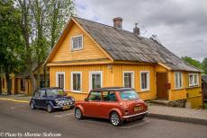 Lithuania 2015 - Classic Car Road Trip: Two classic Minis in front of one of the wooden houses in the historic Town of Trakai in Lithuania. The small Town of...