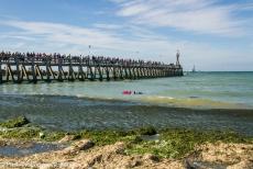 Normandië 2014 - Classic Car Road Trip Normandië: Courseulles-sur-Mer, een bloemenkrans drijft op de golven bij de pier op Juno Beach tijdens de...