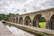 Longbridge IMM - Classic Car Road Trip: A narrowboat on the Llangollen Canal, carried by the Chirk Aqueduct, the railway viaduct behind it. In our own Mini Monza,...